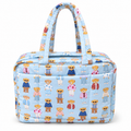 Blue Teddy Bear Weekender Bag front view showing light blue quilted nylon with allover teddy bear print featuring bears in colorful outfits, light blue top zipper, open front slip pocket, and dual padded print handles on white background
