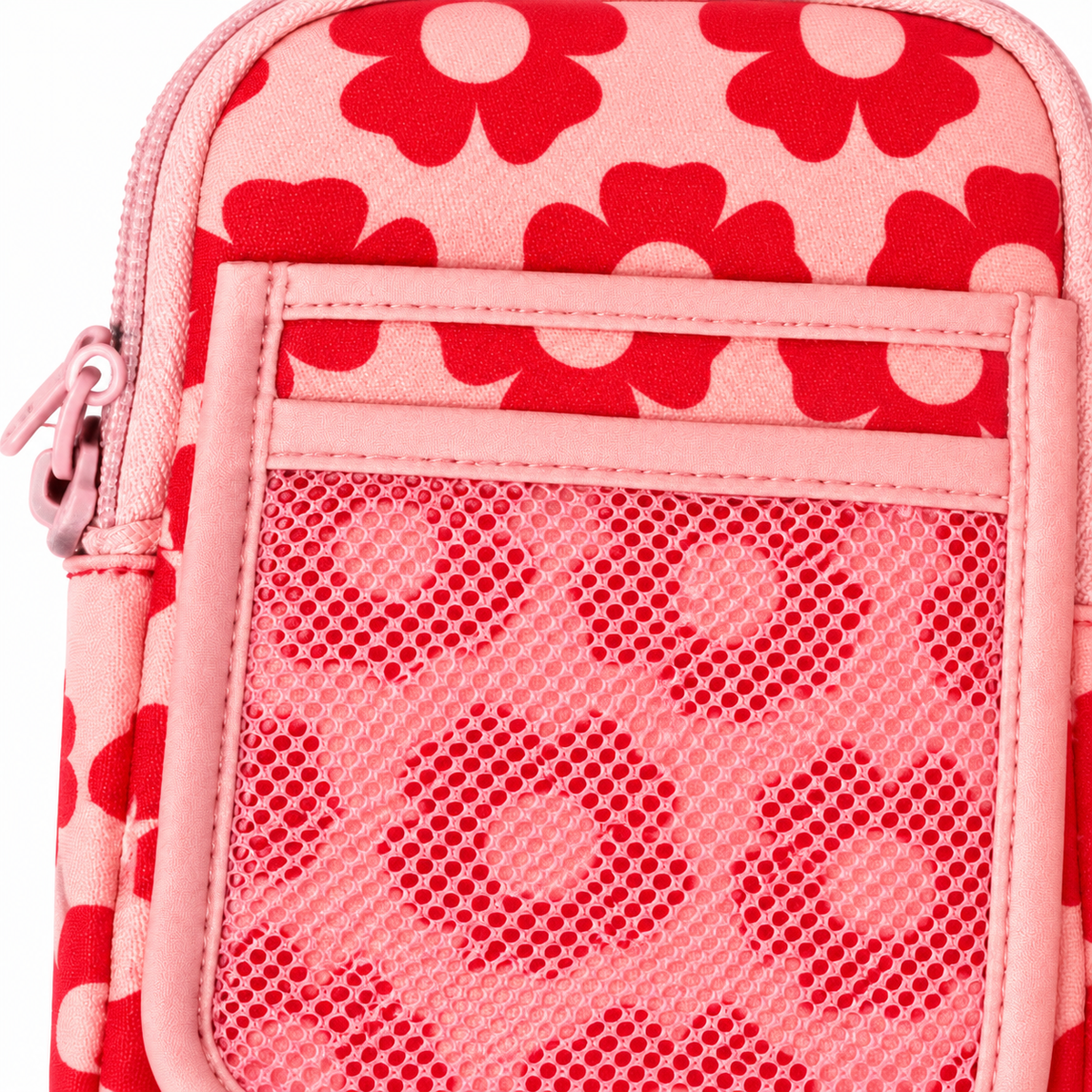 Close-up of Pink Retro Floral Tumbler Pouch showing pink top zipper with pink metal pull, bold red retro daisy print fabric, front slip pocket with pink leather-look trim, and pink mesh pocket with floral print visible through mesh
