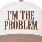 Close-up of I'm the Problem Baseball Cap in Ash Mocha showing mocha raised serif block I'm the Problem embroidery on structured cream cotton crown on white background
