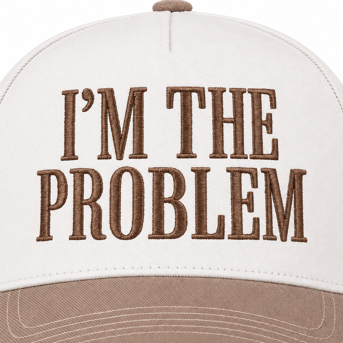 Close-up of I'm the Problem Baseball Cap in Ash Mocha showing mocha raised serif block I'm the Problem embroidery on structured cream cotton crown on white background
