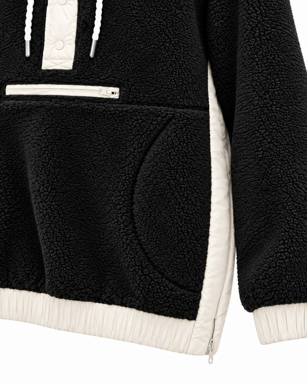 Close-up of the black sherpa hoodie showing the front zippered pocket, curved hand-pocket opening, ivory side panel, and contrasting cuff and hem
