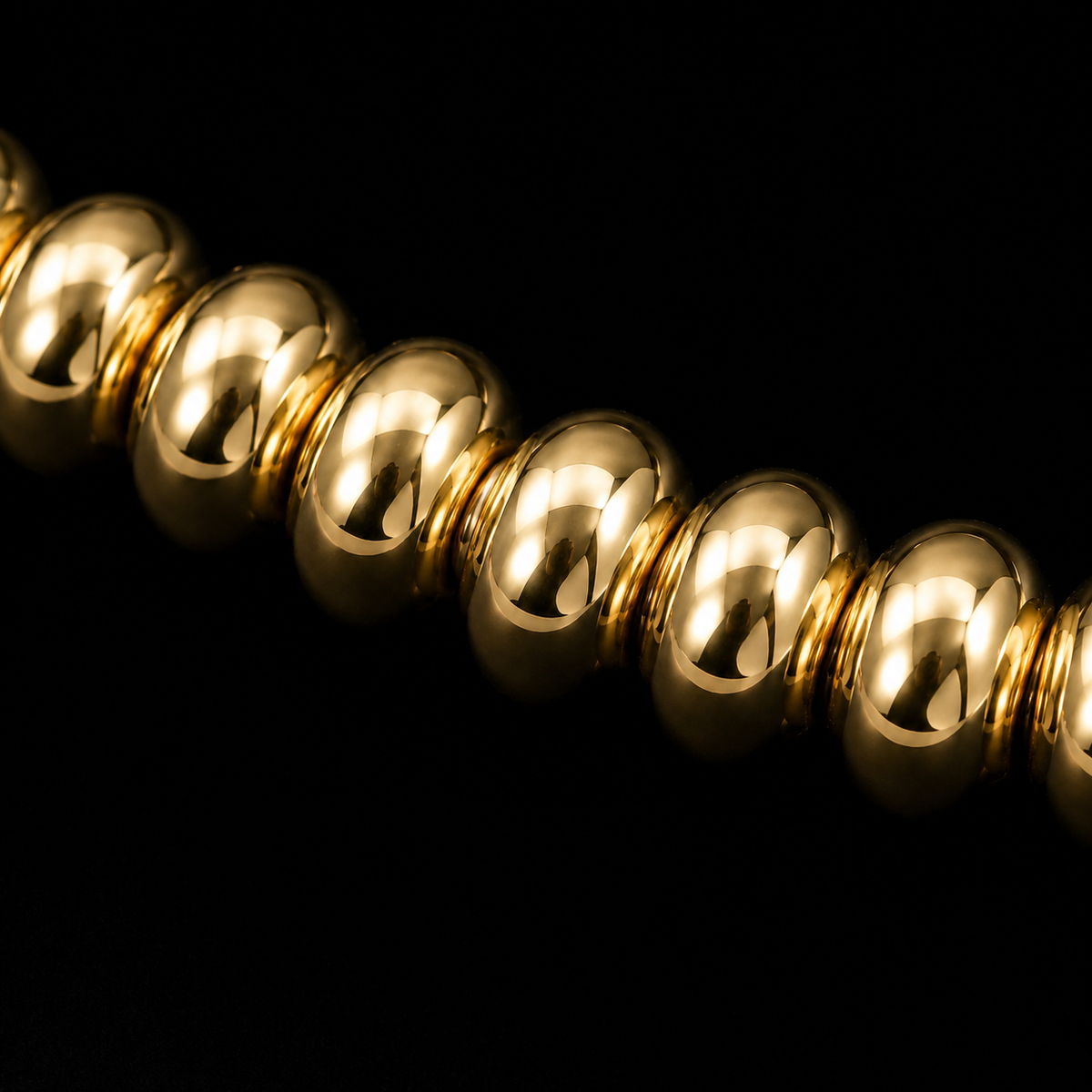 Close-up of polished gold-tone rondelle beads on stretch bracelet showing bead texture and shine

