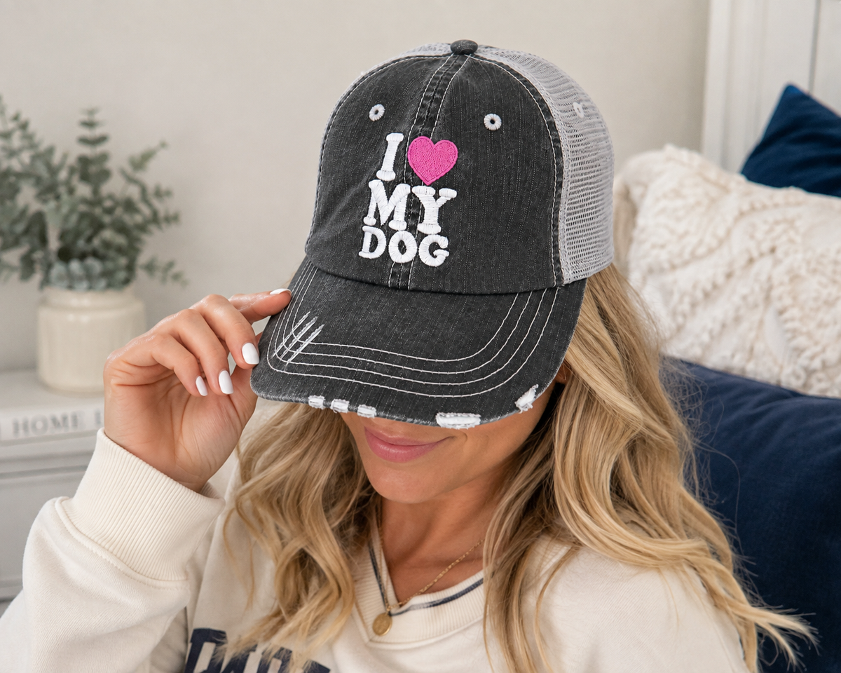 Woman wearing I Love My Dog distressed charcoal trucker hat with pink heart embroidery
