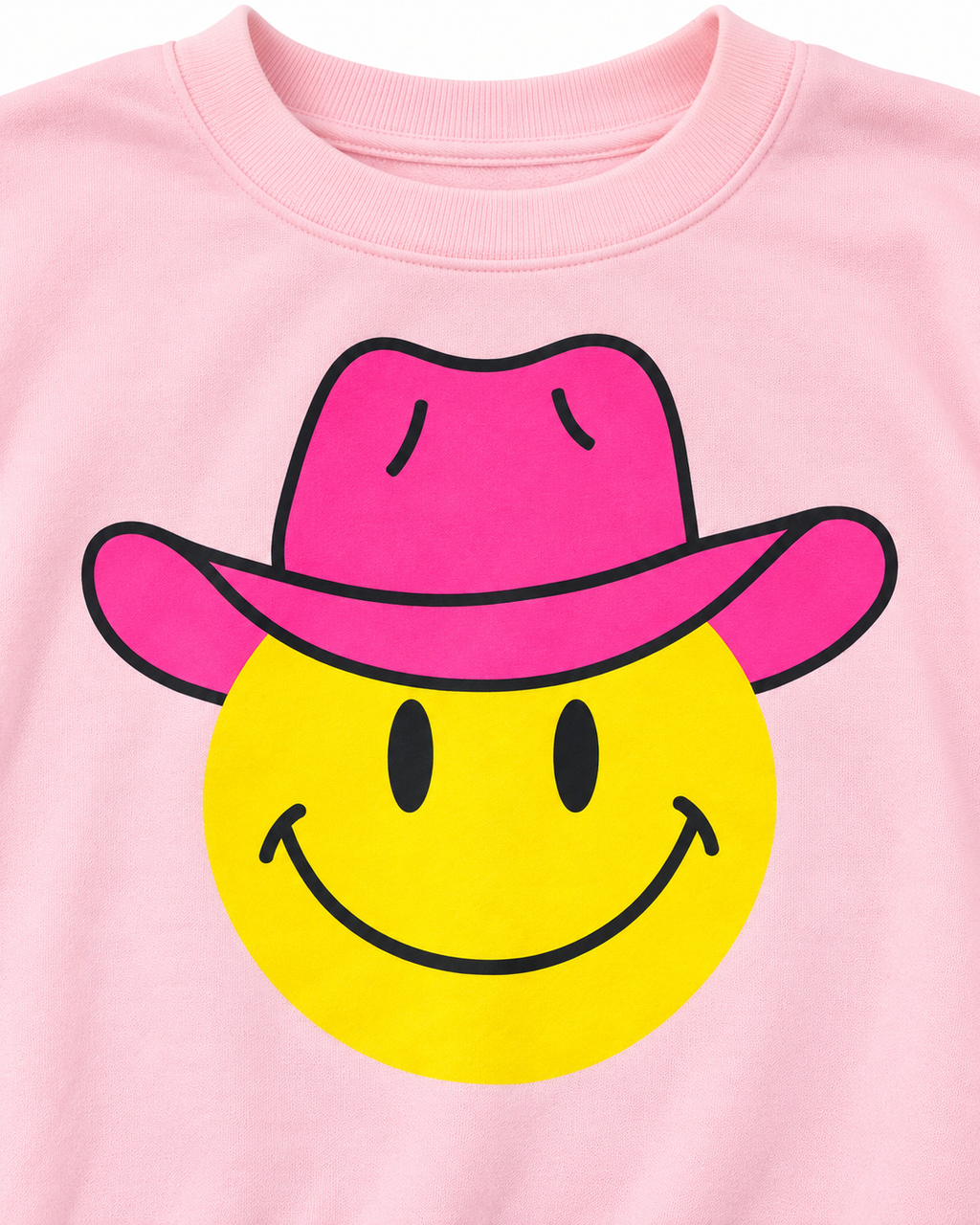 Close-up of the yellow smiley face with black eyes and smile wearing a hot pink cowboy hat on light pink fabric
