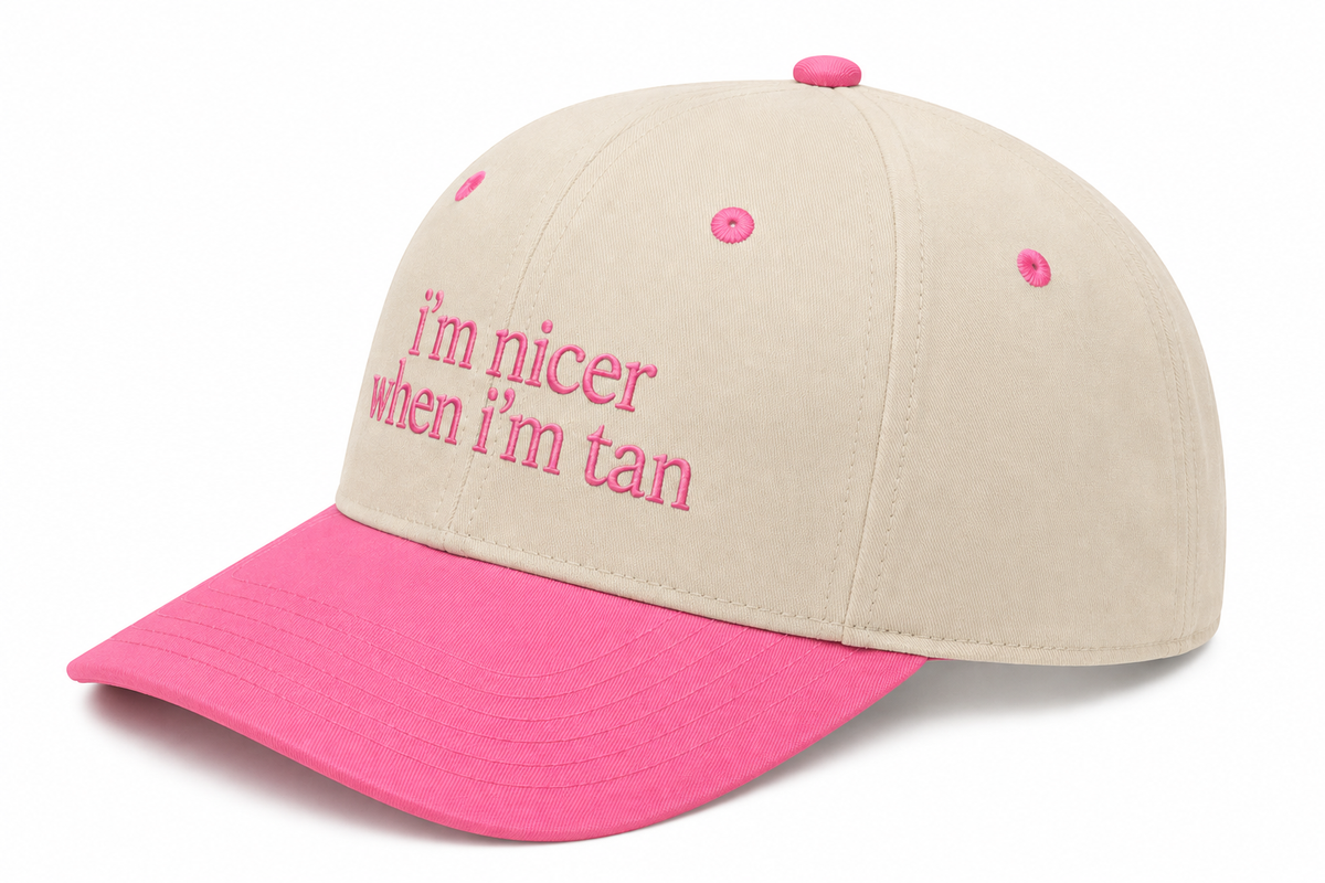 Side view of I'm Nicer When I'm Tan trucker hat in cream with pink brim and solid cream back, shown on a white background.
