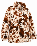 Angled front view of the cow print sherpa pullover showing its quarter-zip neckline, long sleeves, and front pocket with side openings
