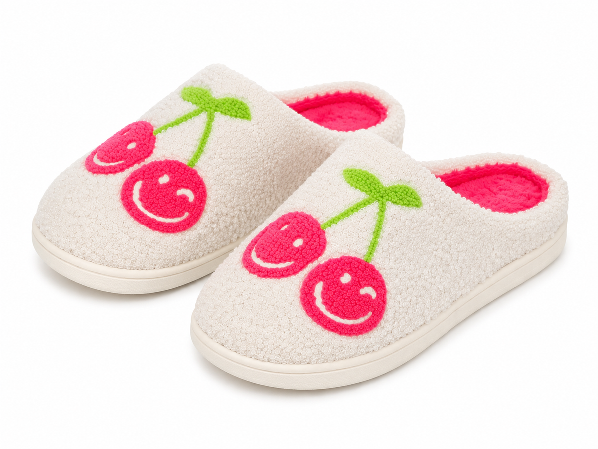 Pair of white smiley cherry cozy slippers showing pink footbed lining and rubber sole
