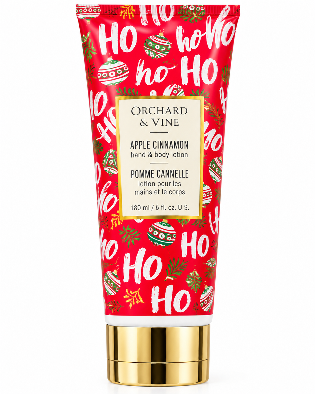 Closer front view of Apple Cinnamon hand and body lotion showing the 180 mL and 6 fl oz label, holiday ornaments, and gold-tone cap
