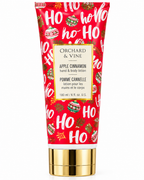 Closer front view of Apple Cinnamon hand and body lotion showing the 180 mL and 6 fl oz label, holiday ornaments, and gold-tone cap
