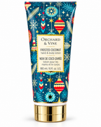 Front view of Orchard & Vine Frosted Coconut hand and body lotion showing blue ornament and snowflake packaging and the 6 fl oz label
