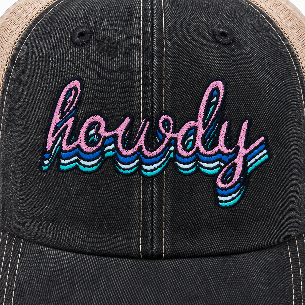 Close-up of retro-style "Howdy" embroidery in pink, blue, teal, and white on distressed black denim hat front panel
