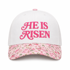 He Is Risen Baseball Cap in Floral front view showing white cotton crown with hot pink decorative script He Is Risen embroidery, pink ditsy floral bill with small floral print, and pink floral top button on white background
