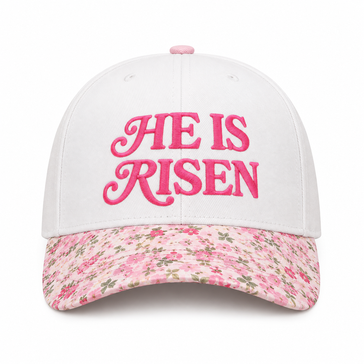 He Is Risen Baseball Cap in Floral front view showing white cotton crown with hot pink decorative script He Is Risen embroidery, pink ditsy floral bill with small floral print, and pink floral top button on white background
