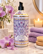 Molto Bella Florence Orchid body wash in a purple floral pump bottle styled with orchids, purple towels, candles, and a bath brush
