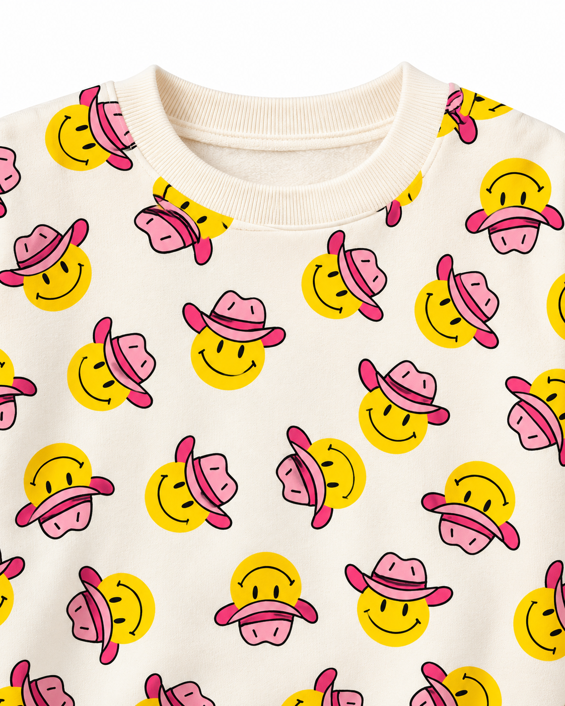 Close-up of yellow smiley faces wearing pink cowgirl hats beside the cream ribbed crew neckline
