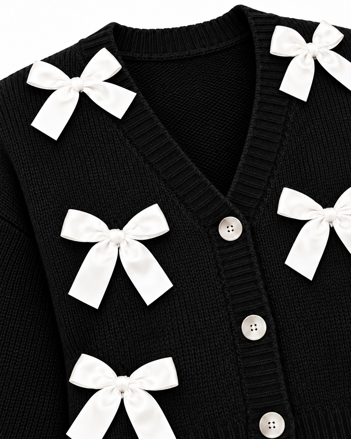 Close-up of Black Satin Bow Knit Cardigan showing deep V-neckline with ribbed trim, pearl dome buttons along button placket, and white satin ribbon bow detail on black ribbed knit on white background
