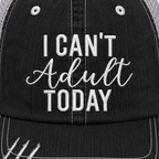 Close-up of I Can't Adult Today trucker hat showing white embroidered lettering on distressed black denim front panel.