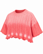 Three-quarter view of the pink slouchy cable-knit sweater showing its oversized shape and cropped hem
