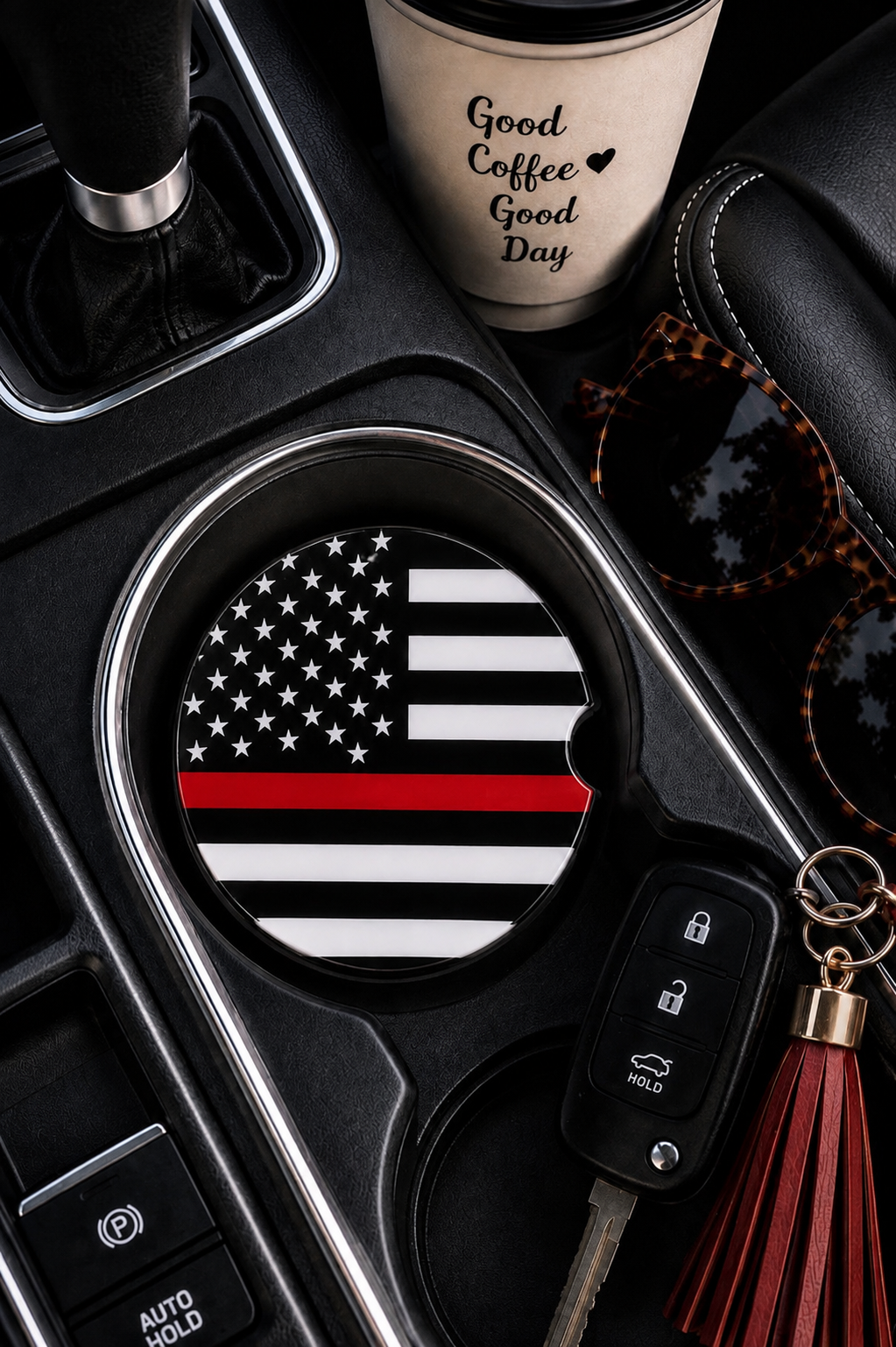 Thin Red Line ceramic car coaster in cup holder — black and white American flag with thin red line design, shown in car console with coffee cup and sunglasses
