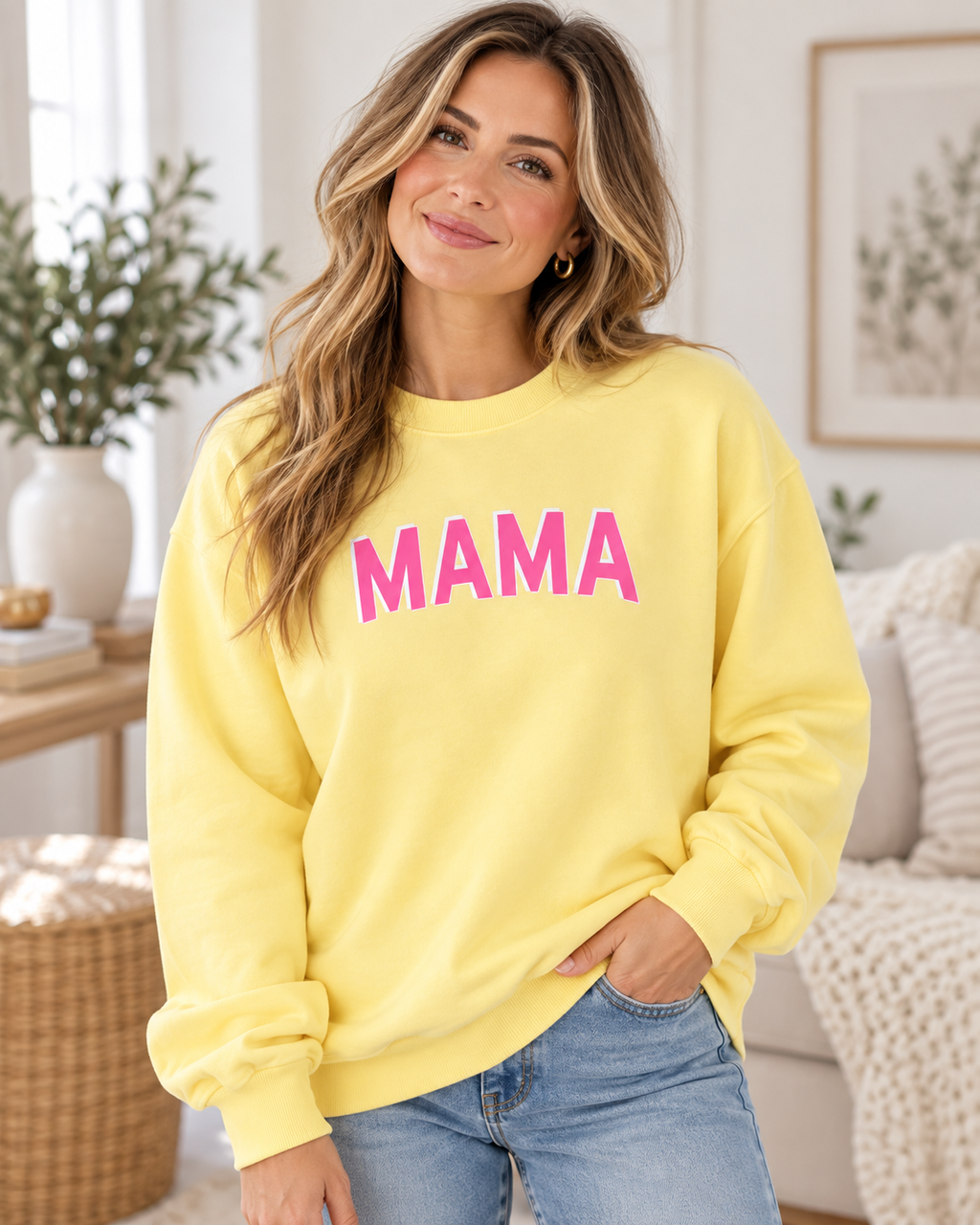 Model wearing a yellow MAMA crewneck sweatshirt with pink lettering and blue jeans
