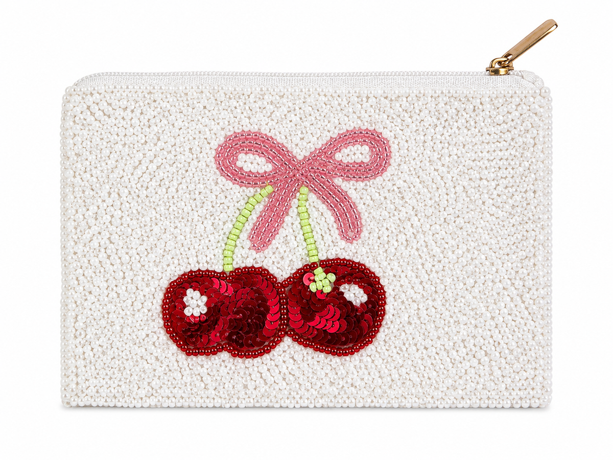 A white beaded zip pouch featuring an embroidered cherry design with red sequins, a pink beaded bow, and green stems, shown on a plain white background.