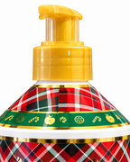 Close-up of the gold-colored hand soap pump and plaid bottle shoulder with decorative apple, candy, and citrus motifs
