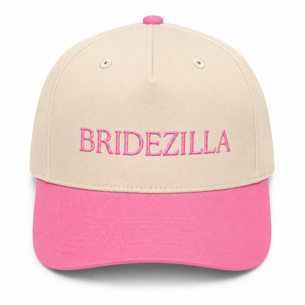 Bridezilla Baseball Cap in cream crown with hot pink brim and bold pink embroidered lettering, shown on a white background.
