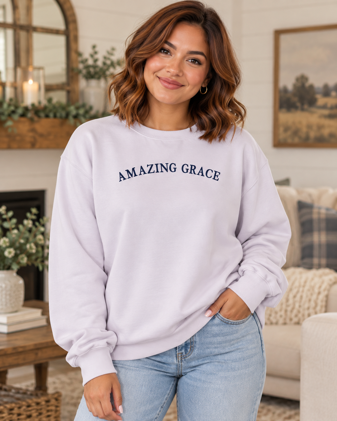 Model wearing a light lavender Amazing Grace crewneck sweatshirt with navy lettering and light-wash jeans
