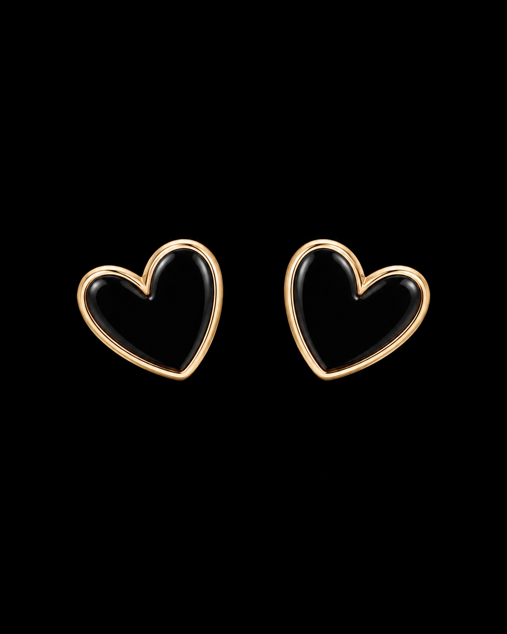 Black enamel heart stud earrings with polished gold-tone bezel trim shown as a pair front-facing on black background
