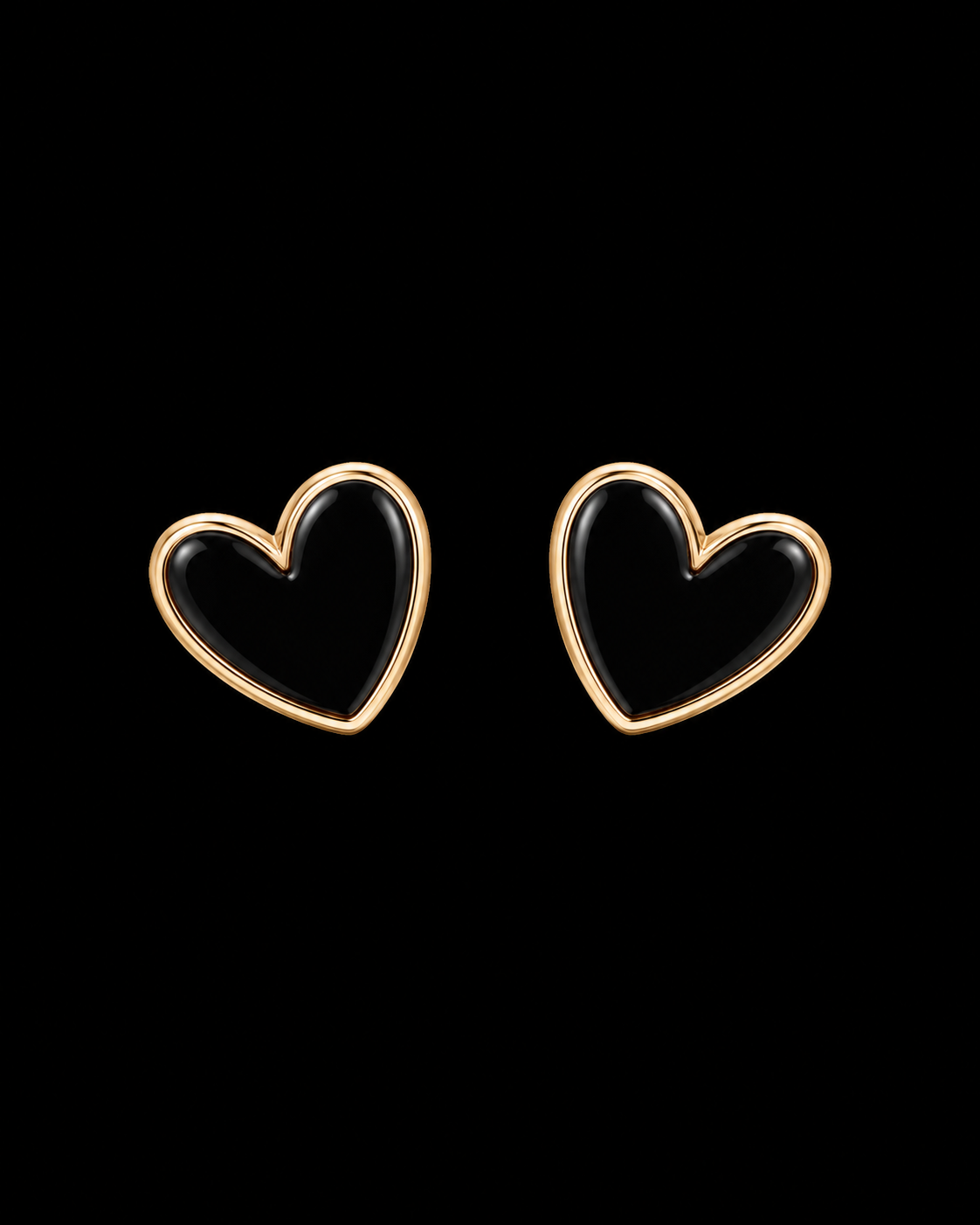 Black enamel heart stud earrings with polished gold-tone bezel trim shown as a pair front-facing on black background
