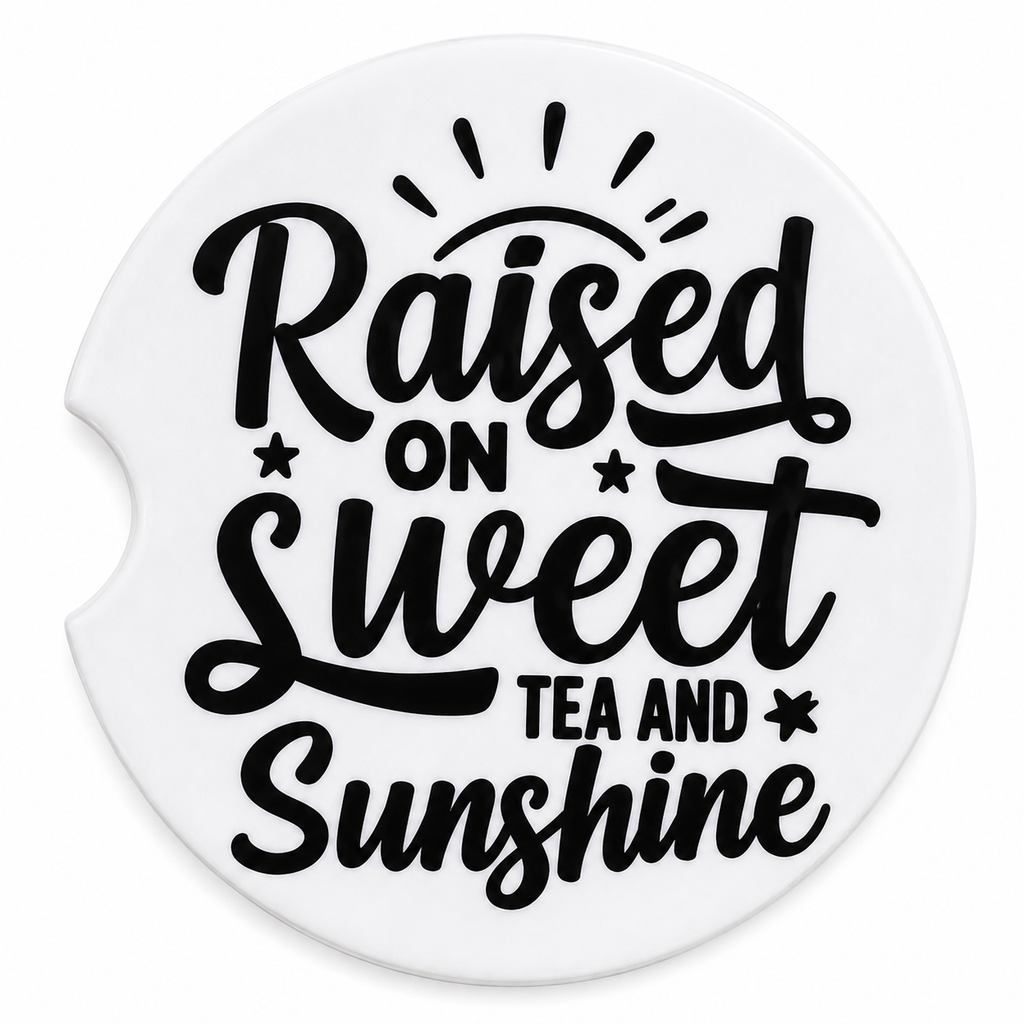 Raised on Sweet Tea and Sunshine ceramic car coaster — bold black script with sun rays and star accents on white, angled view showing finger notch cutout
