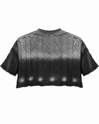 Back view flat lay of black ombre cable knit cropped sweater showing short sleeves and distressed hem on white background

