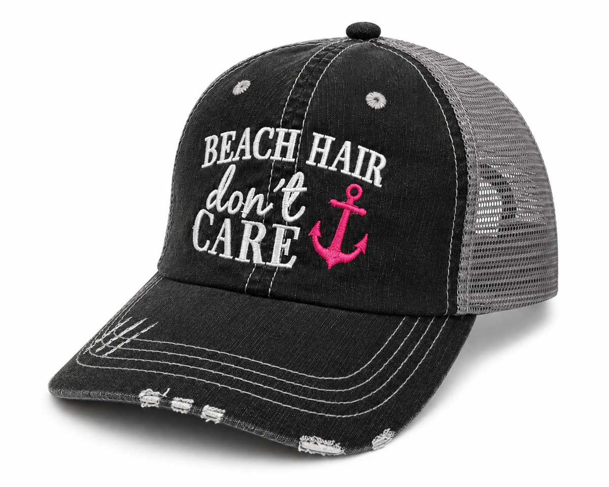 Side view of Beach Hair Don’t Care trucker hat with distressed black front, gray mesh back, white embroidery and bright pink anchor