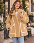 Model wearing a tan sherpa jacket with contrast trim, a high collar, and two front pockets

