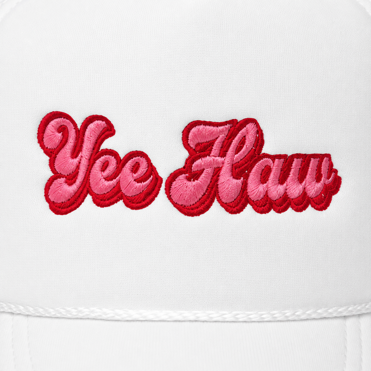 Close-up of pink and red Yee Haw retro script embroidery on white trucker hat
