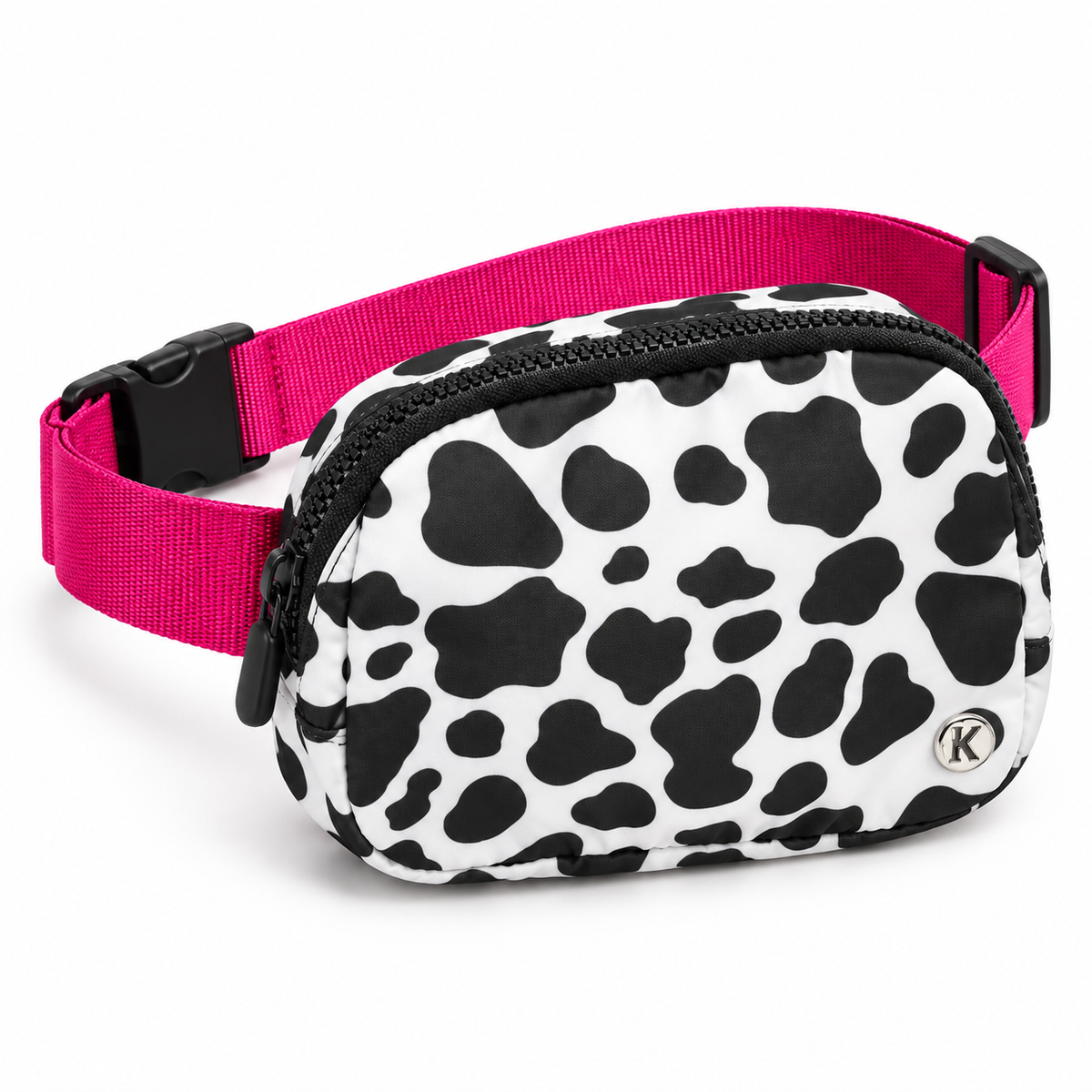Cow Print Belt Bag three-quarter angle view showing rounded oval white nylon with large black cow print spots, black top zipper, silver Katydid K logo rivet, and hot pink webbing strap with black D-ring adjuster and black side-release buckle on white background
