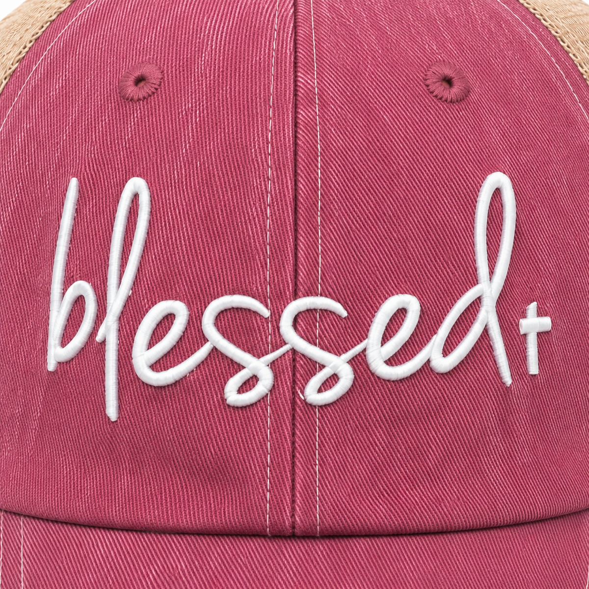 Close-up of white Blessed+ embroidery with a subtle cross accent on the dusty rose front panel of the trucker hat.