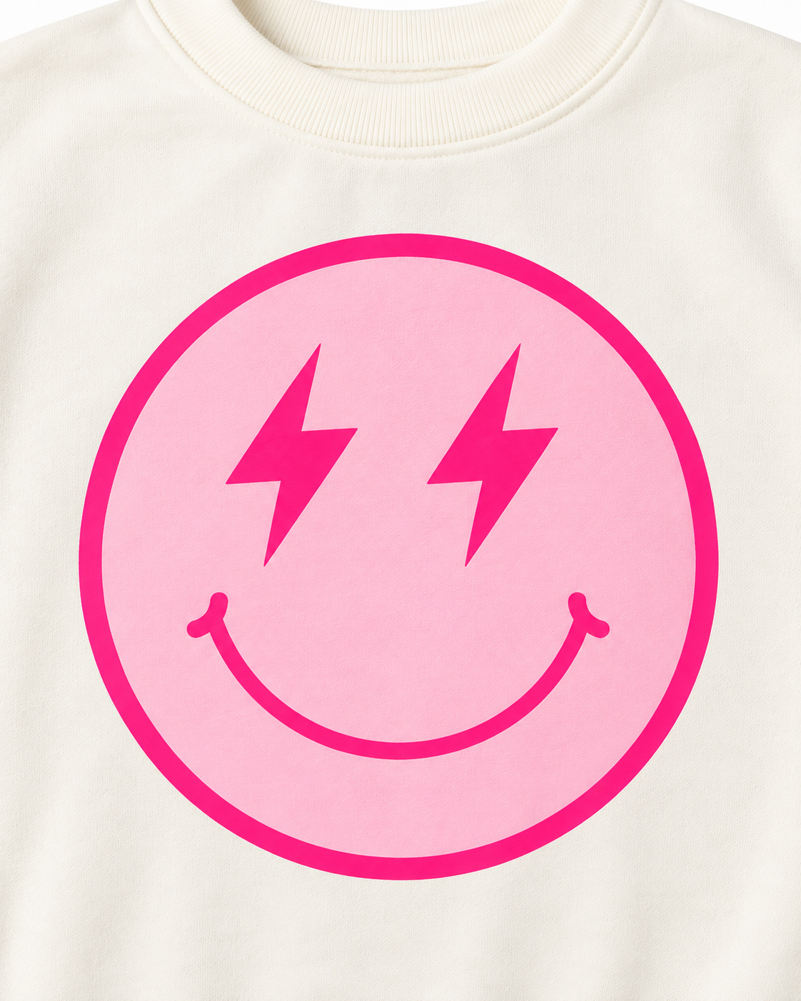 Close-up of the light pink smiley face with hot pink lightning-bolt eyes, smile, and circular border on cream fabric
