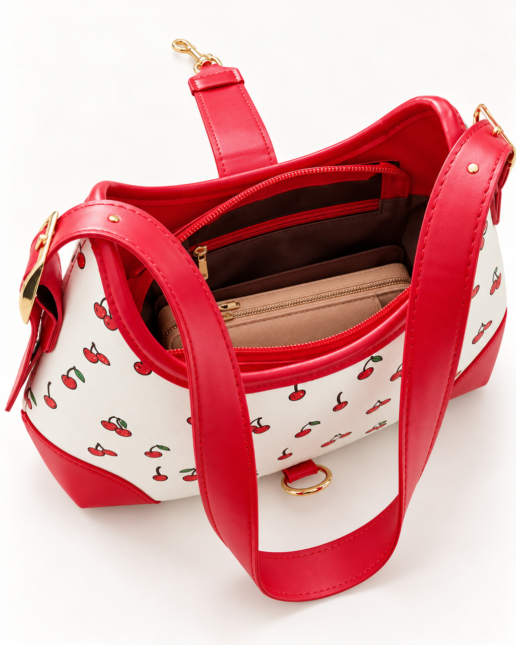 Red and white cherry print handbag with red straps and gold hardware, shown open to display the spacious interior, zippered pocket, and storage compartments.
