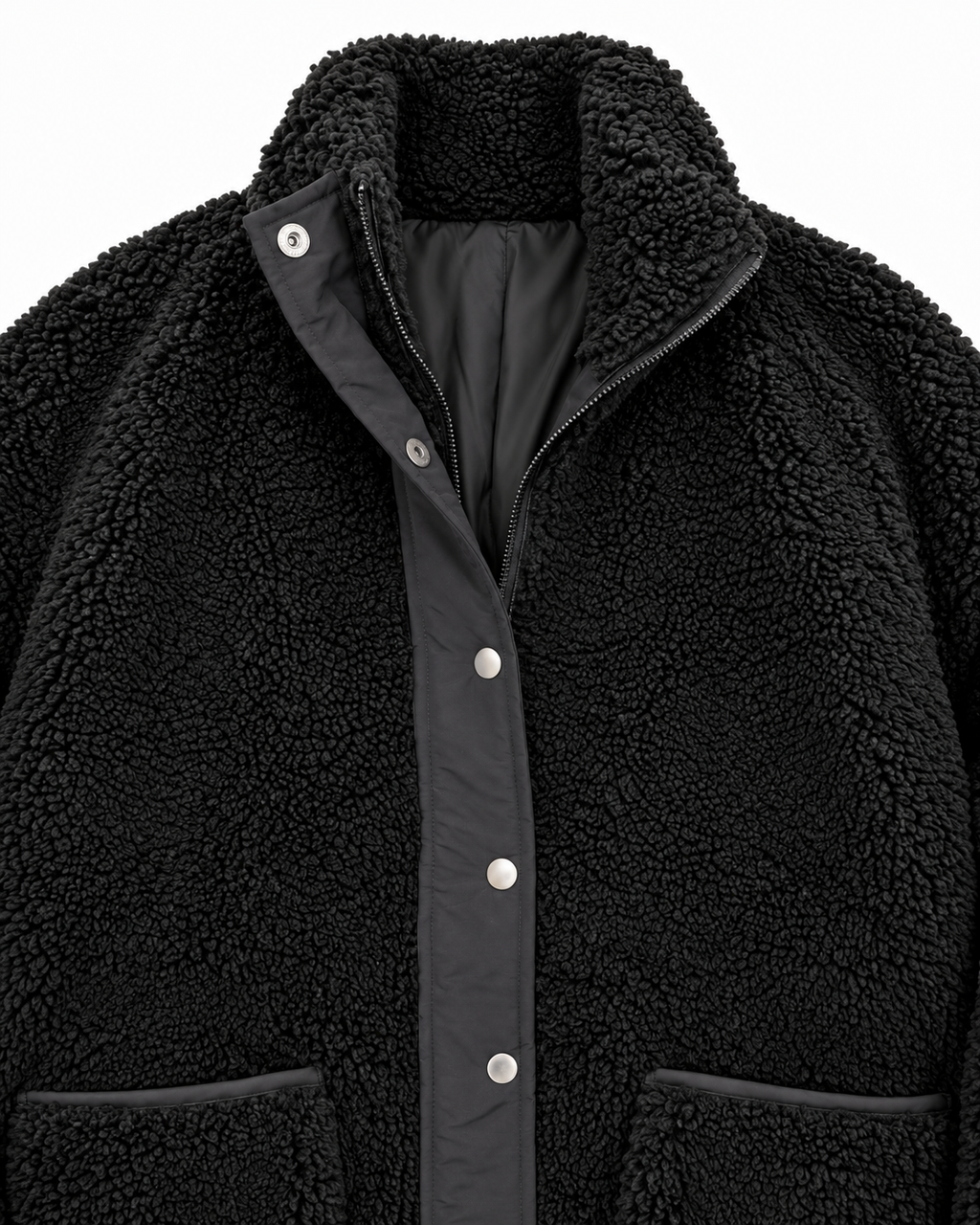 Close-up of the black sherpa jacket showing its stand-up collar, zipper, silver-tone snaps, smooth black placket, and pocket trim
