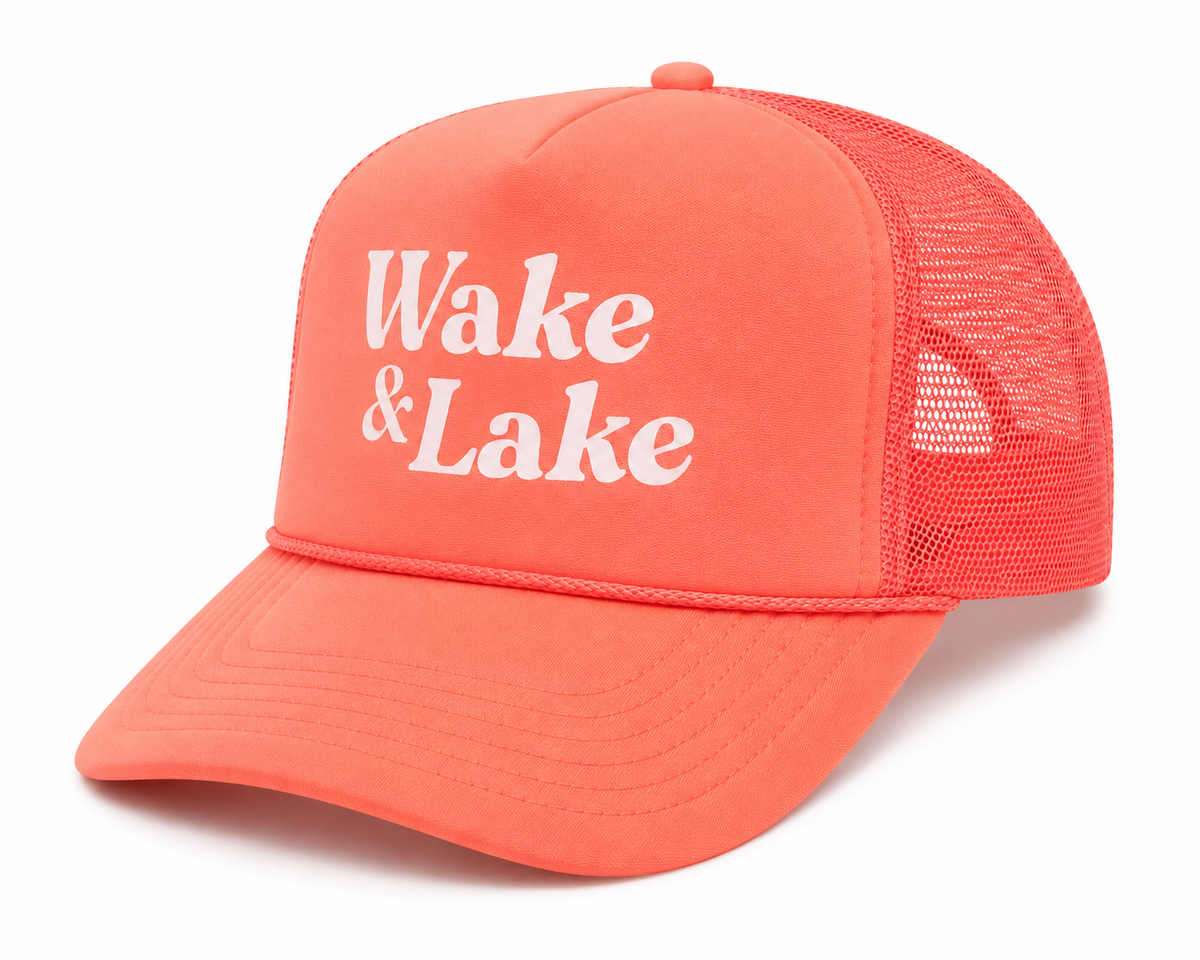 Side view of Wake & Lake Trucker Hat showing coral foam front, mesh back panels, and structured trucker silhouette, on a white background.
