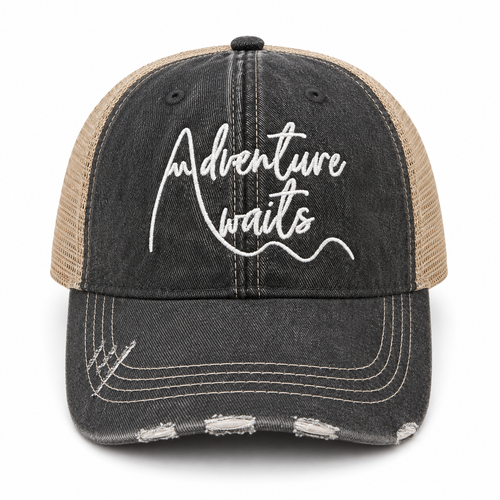 Distressed black trucker hat with white Adventure Awaits script embroidery and tan mesh back, front view
