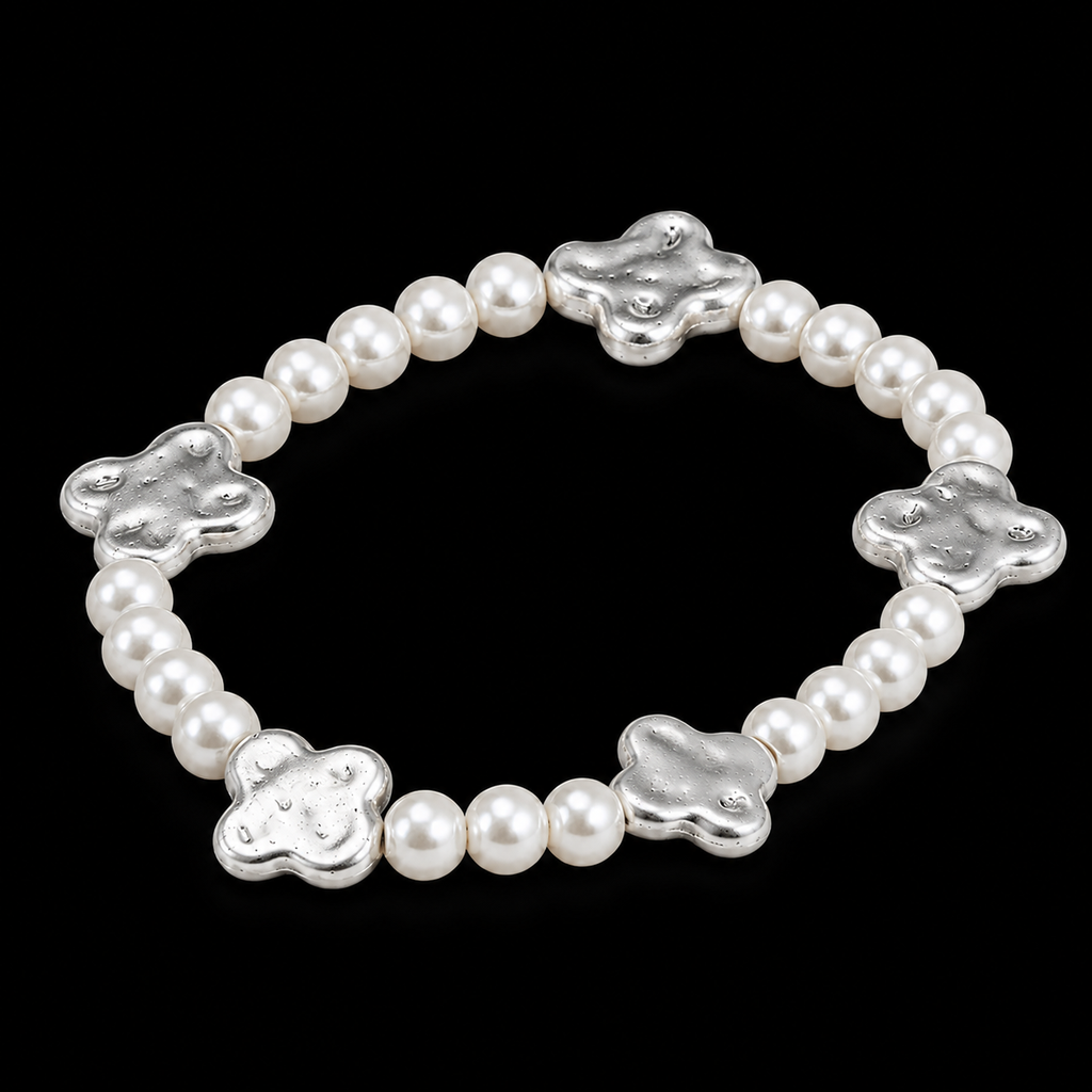 Pearl bead stretch bracelet with hammered silver-tone clover accents shown at an angle on black reflective surface
