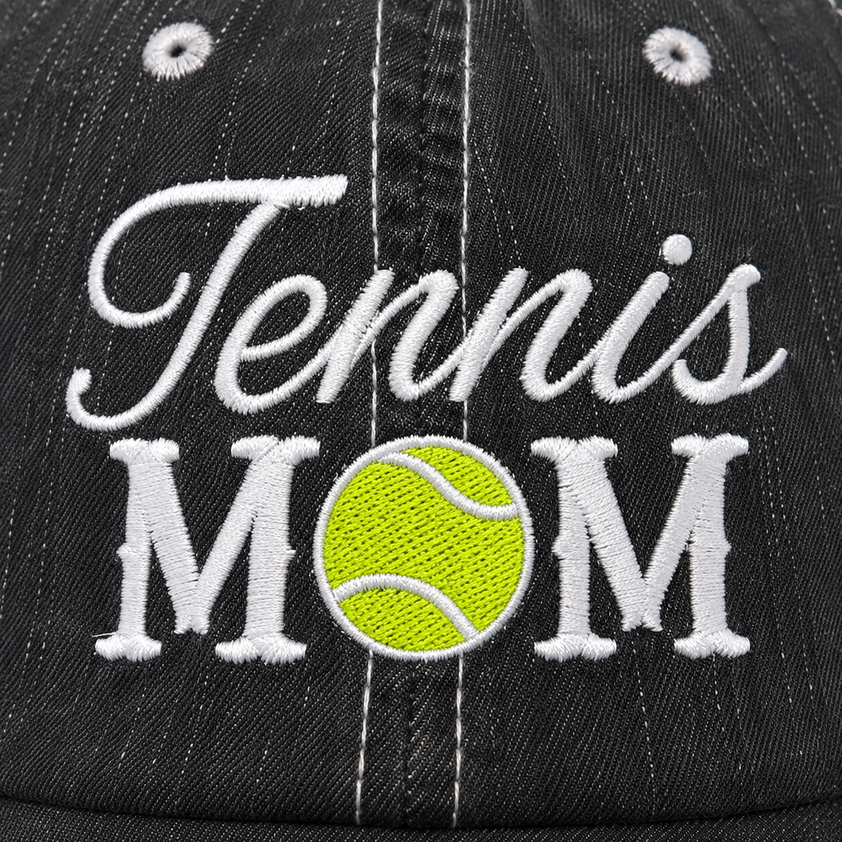 Close-up of embroidered Tennis Mom design on a distressed charcoal trucker hat with yellow tennis ball replacing the letter O
