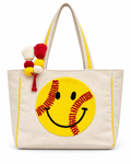 Softball Smiley Tote Bag front view with natural canvas body, large yellow textured softball smiley face with red stitching, yellow trim, and red yellow and cream pom-pom tassel accent on white background
