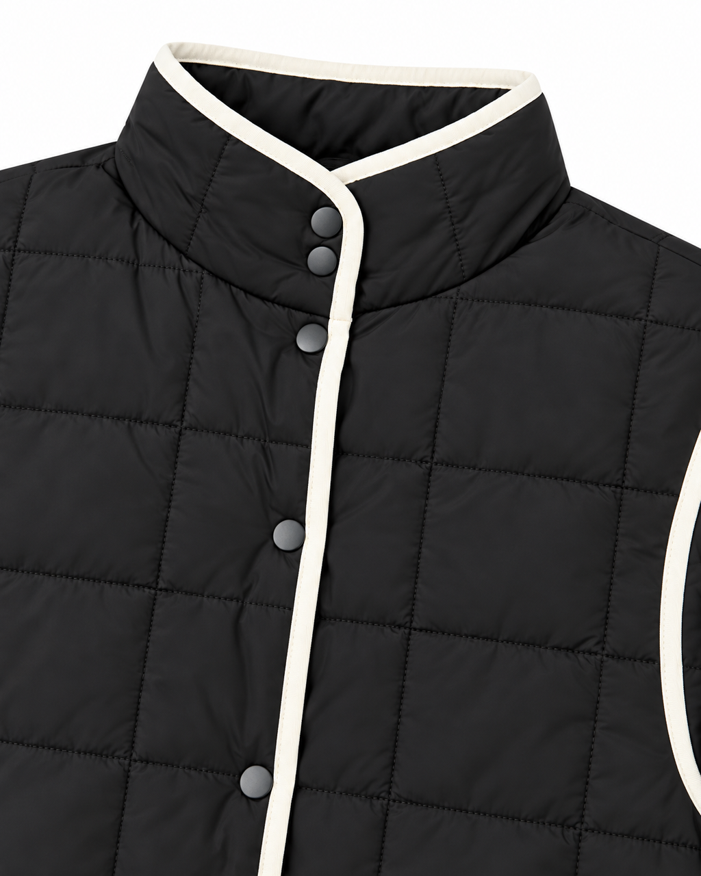Close-up of Black Quilted Contrast Trim Jacket showing stand-up collar with cream contrast trim and gunmetal snap buttons along button placket on black grid-quilted fabric
