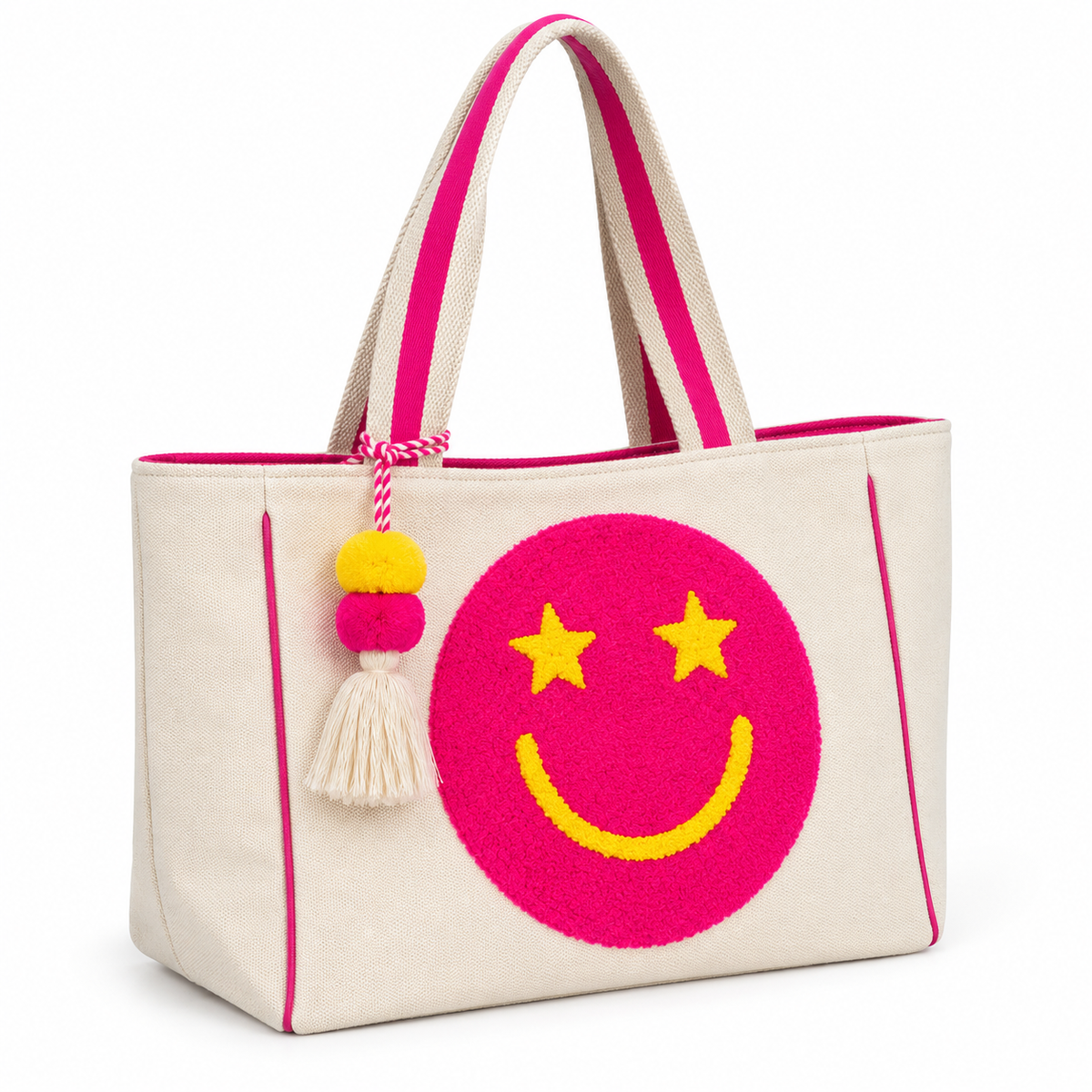 Pink Star Smiley Canvas Tote Bag three-quarter angle view showing natural canvas body with oversized hot pink chenille smiley face patch, yellow star eyes and smile, hot pink trim piping on sides and base, pink-striped dual shoulder handles, and pom-pom tassel charm on white background
