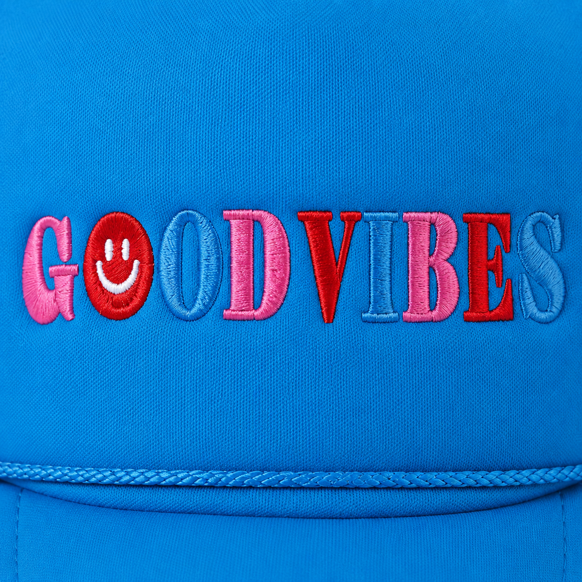 Close-up of multicolor embroidered "Good Vibes" lettering in pink, red, and periwinkle with a red smiley face accent on a bright sky blue trucker hat foam front panel with rope accent along the brim.
