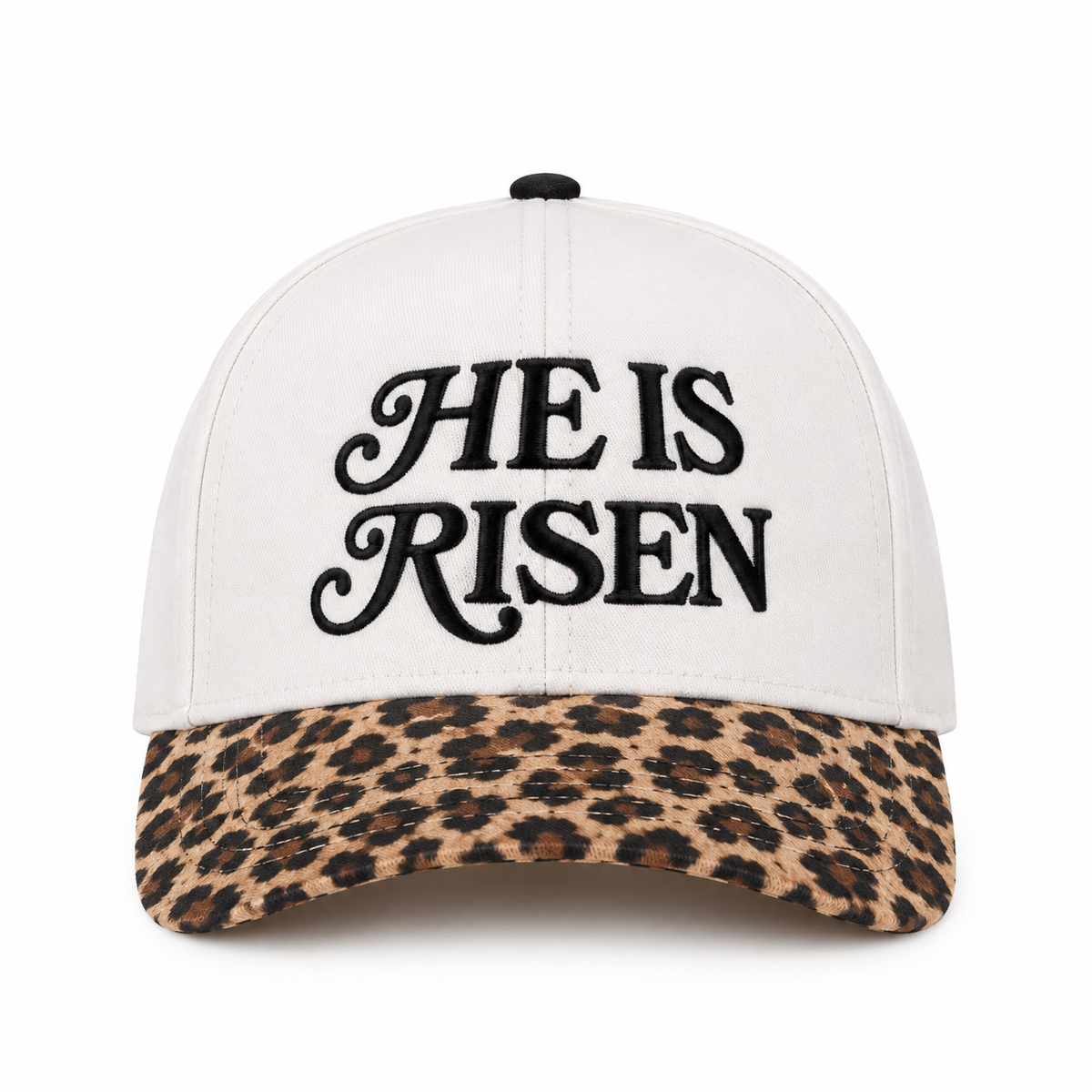 He Is Risen Baseball Cap in Leopard front view showing cream cotton crown with black decorative script He Is Risen embroidery, tan and brown leopard print bill, and black top button on white background
