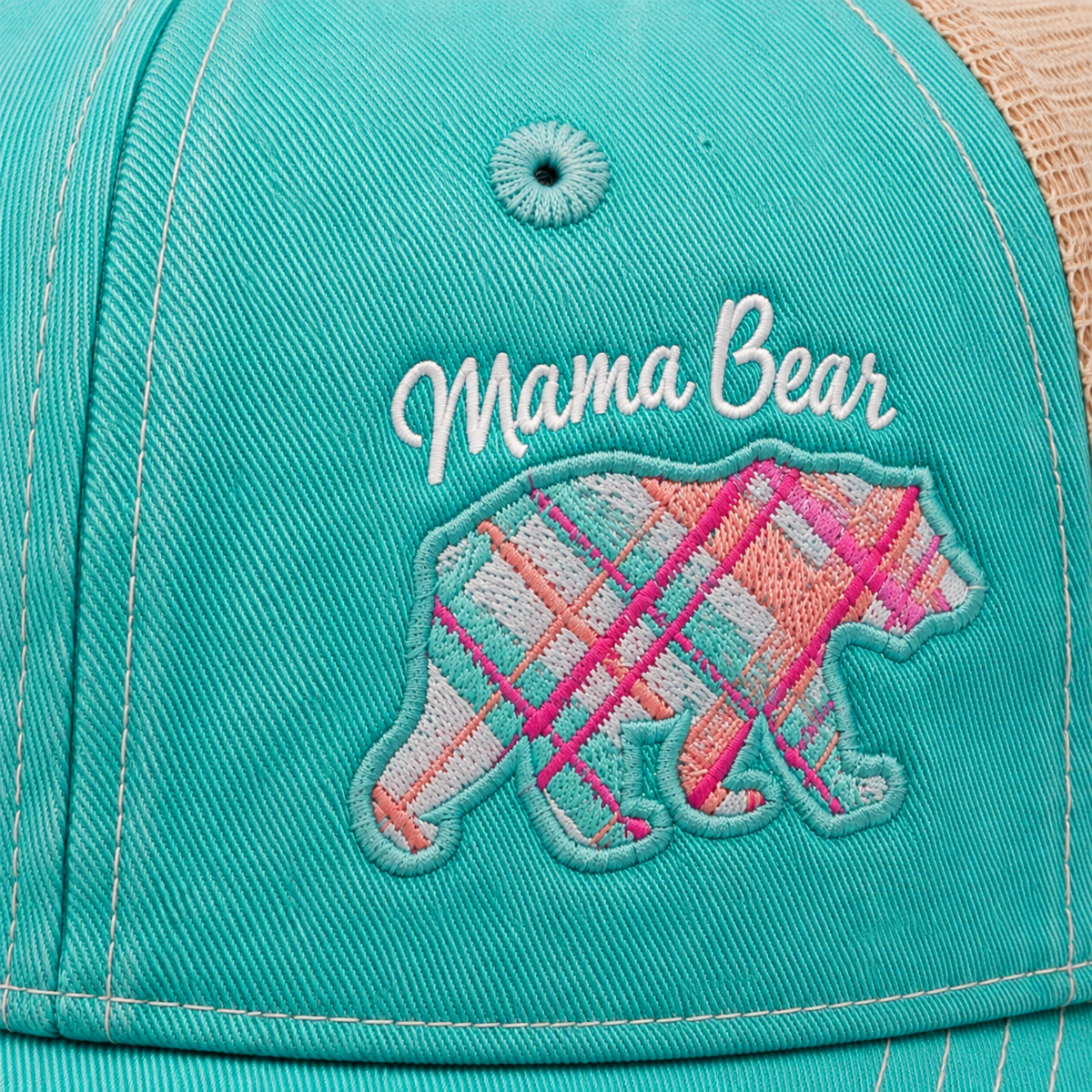 Close-up of Mama Bear script embroidery above colorful plaid bear patch on distressed aqua trucker hat
